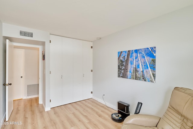 unfurnished room with light wood finished floors, baseboards, and visible vents