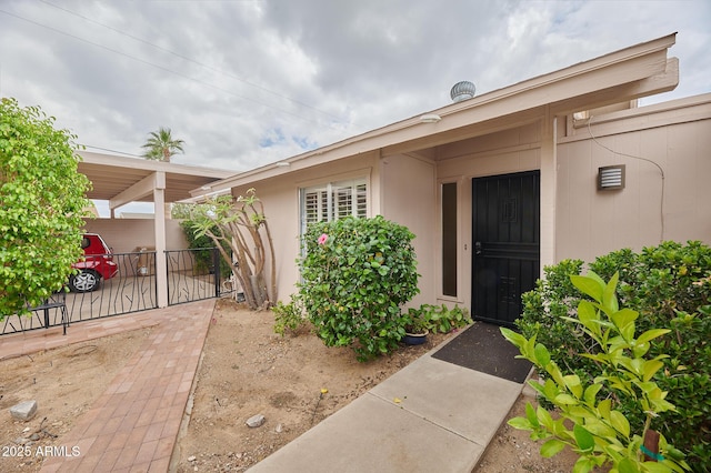 entrance to property featuring a patio area and fence
