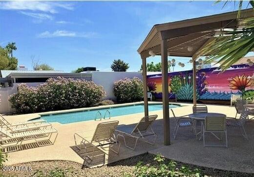 community pool featuring a patio and a fenced backyard