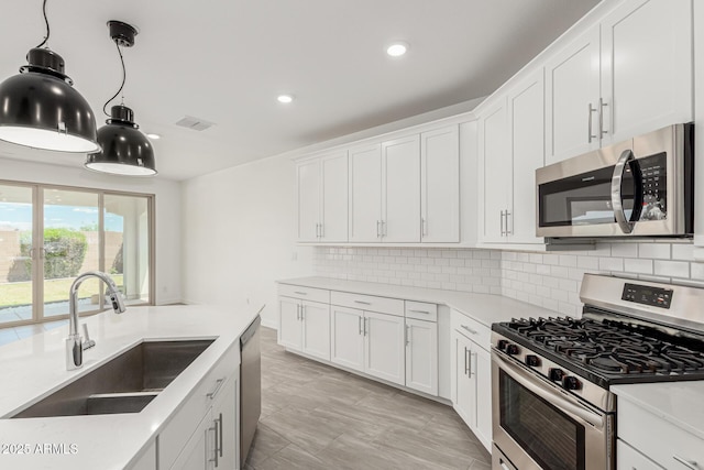4051 S Galaxy Ln, Mesa, AZ 85212 - kitchen with stainless steel appliances, a sink, decorative backsplash, recessed lighting, and white cabinetry