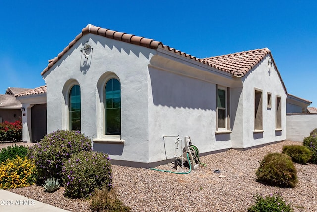 4051 S Galaxy Ln, Mesa, AZ 85212 - view of side of home featuring stucco siding, a tile roof, and an attached garage