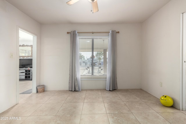 tiled spare room with ceiling fan