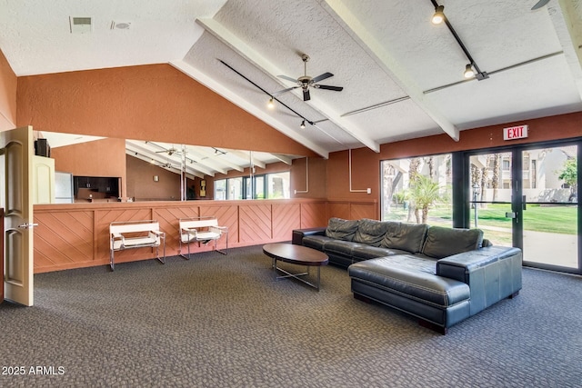 living room featuring visible vents, a healthy amount of sunlight, vaulted ceiling with beams, and a textured ceiling