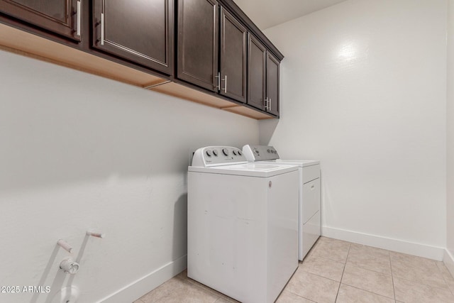 washroom with baseboards, cabinet space, light tile patterned floors, and washer and dryer
