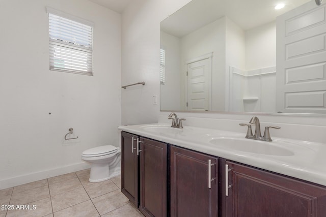 bathroom with baseboards, a healthy amount of sunlight, and a sink