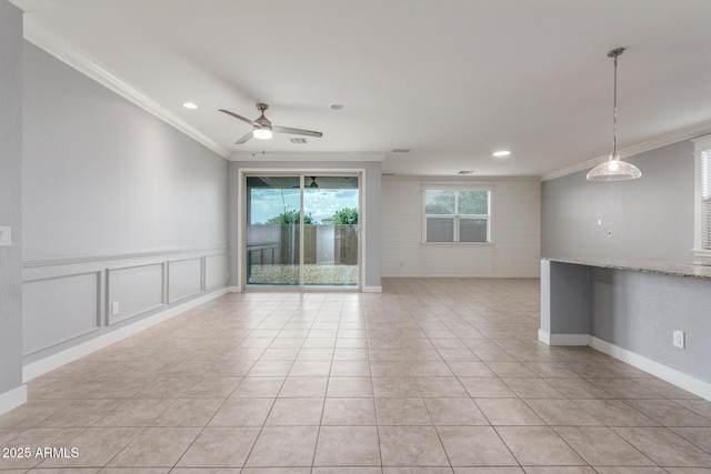 empty room featuring a ceiling fan, crown molding, light tile patterned floors, a decorative wall, and recessed lighting