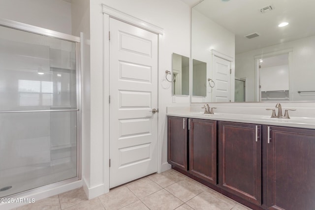 bathroom with a sink, double vanity, tile patterned floors, visible vents, and a stall shower