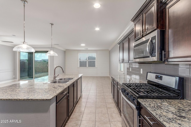 kitchen with dark brown cabinetry, appliances with stainless steel finishes, a sink, decorative backsplash, and ornamental molding
