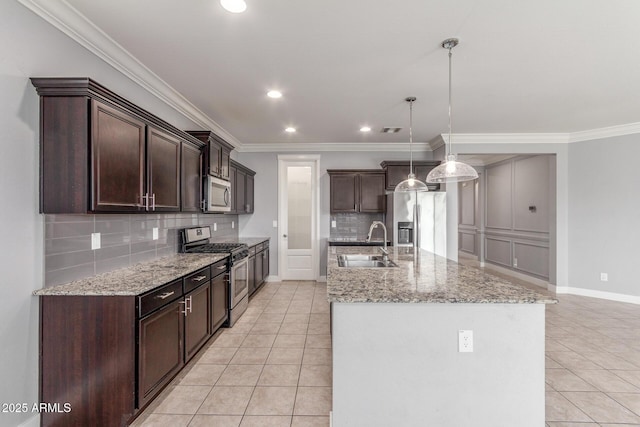 kitchen with appliances with stainless steel finishes, tasteful backsplash, dark brown cabinets, a sink, and light tile patterned floors