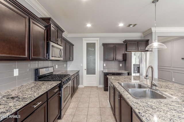 kitchen featuring dark brown cabinets, appliances with stainless steel finishes, a sink, backsplash, and visible vents