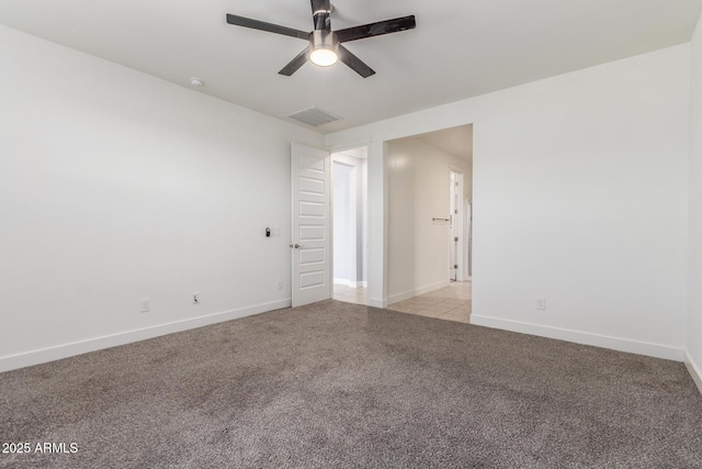 spare room with baseboards, light carpet, a ceiling fan, and visible vents