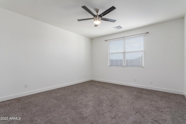 spare room with baseboards, a ceiling fan, dark carpet, and visible vents