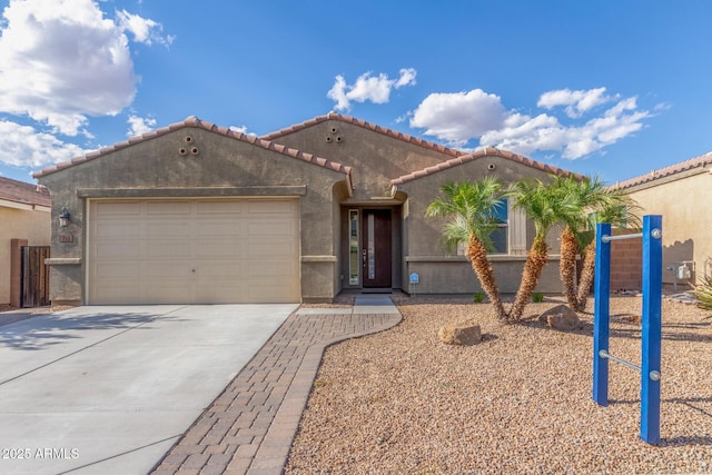 mediterranean / spanish home featuring a garage, stucco siding, driveway, and a tile roof