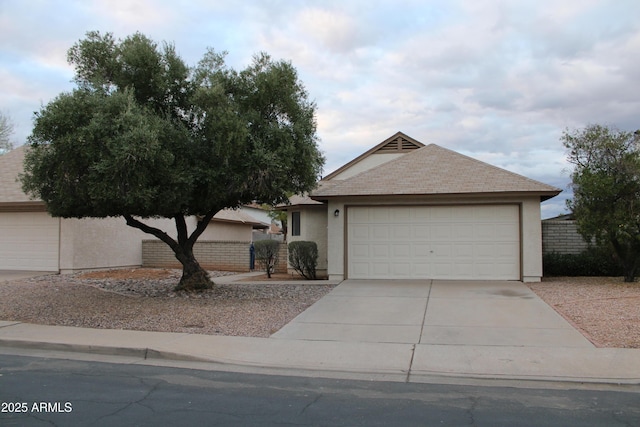 ranch-style home with fence, a garage, driveway, and stucco siding