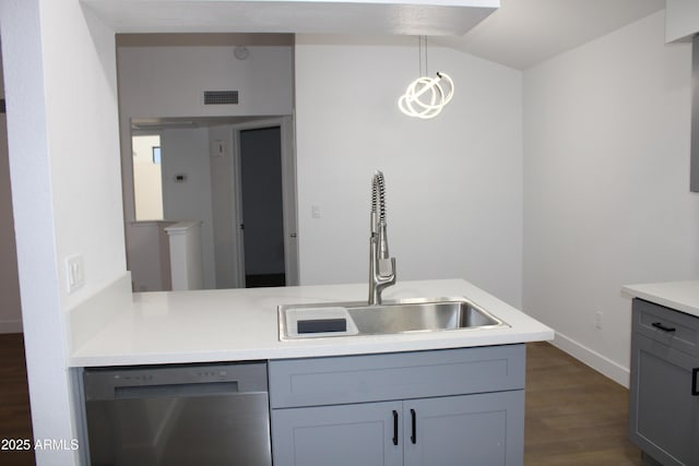 kitchen with dark wood finished floors, dishwasher, light countertops, lofted ceiling, and a sink