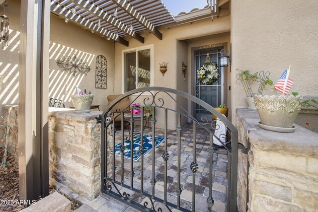 6975 E Lynx Wagon Rd, Prescott Valley, AZ 86314 - property entrance featuring a gate, a pergola, and stucco siding