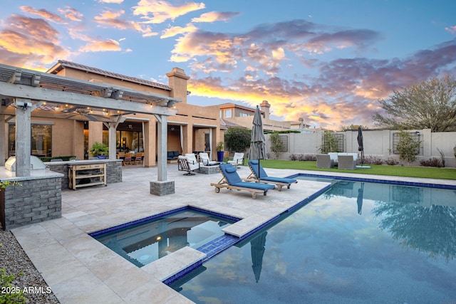 pool at dusk with an outdoor hangout area, an in ground hot tub, and a patio area