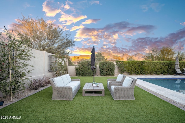 yard at dusk featuring an outdoor hangout area, a fenced in pool, and a mountain view