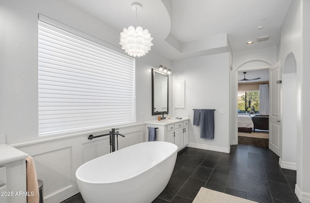 bathroom with a bathtub, a chandelier, and vanity