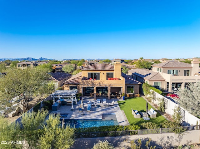 rear view of house featuring a patio, a lawn, and an outdoor living space