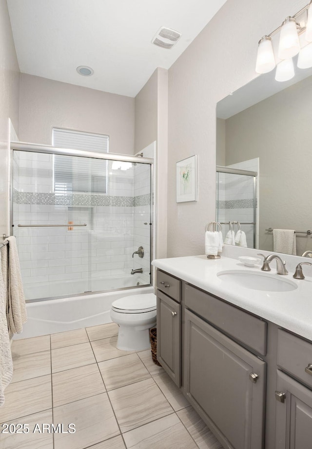 full bathroom with vanity, tile patterned floors, combined bath / shower with glass door, and toilet