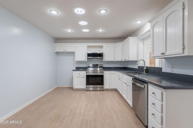 405 E Stanford Ave, Gilbert, AZ 85234 - kitchen featuring appliances with stainless steel finishes, a sink, dark countertops, light wood-type flooring, and white cabinets