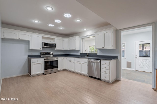 405 E Stanford Ave, Gilbert, AZ 85234 - kitchen with appliances with stainless steel finishes, a sink, dark countertops, white cabinets, and baseboards
