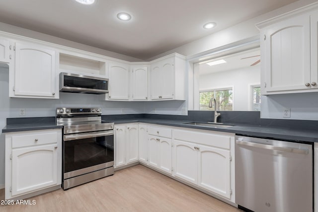 405 E Stanford Ave, Gilbert, AZ 85234 - kitchen with appliances with stainless steel finishes, a sink, dark countertops, light wood finished floors, and recessed lighting