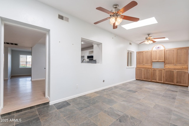 405 E Stanford Ave, Gilbert, AZ 85234 - unfurnished living room featuring a ceiling fan, a skylight, and baseboards