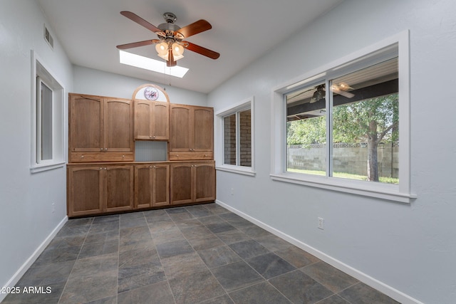 405 E Stanford Ave, Gilbert, AZ 85234 - unfurnished dining area with a ceiling fan, baseboards, and a skylight