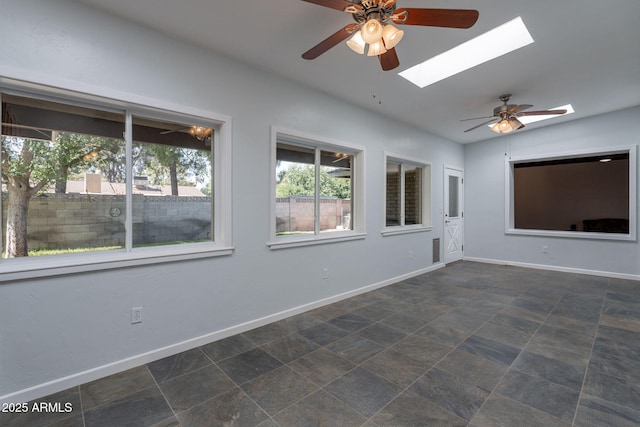 405 E Stanford Ave, Gilbert, AZ 85234 - unfurnished room featuring a skylight, ceiling fan, baseboards, vaulted ceiling, and stone finish flooring