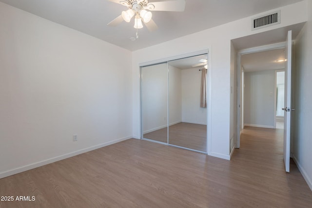405 E Stanford Ave, Gilbert, AZ 85234 - unfurnished bedroom featuring wood finished floors, a closet, baseboards, and ceiling fan