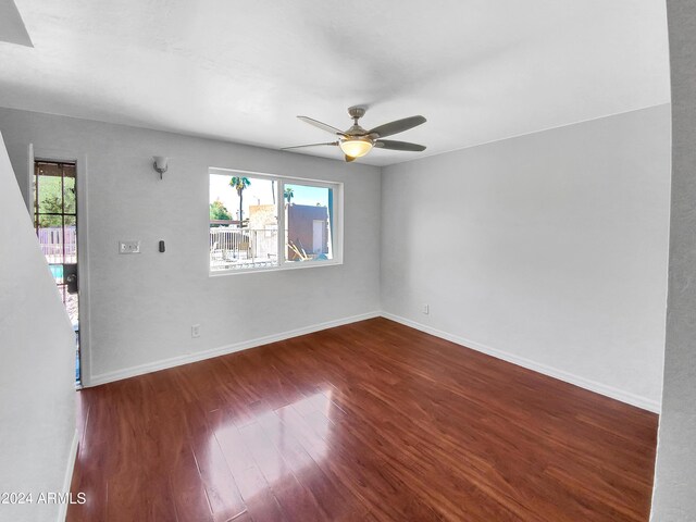 spare room featuring dark hardwood / wood-style floors, a wealth of natural light, and ceiling fan