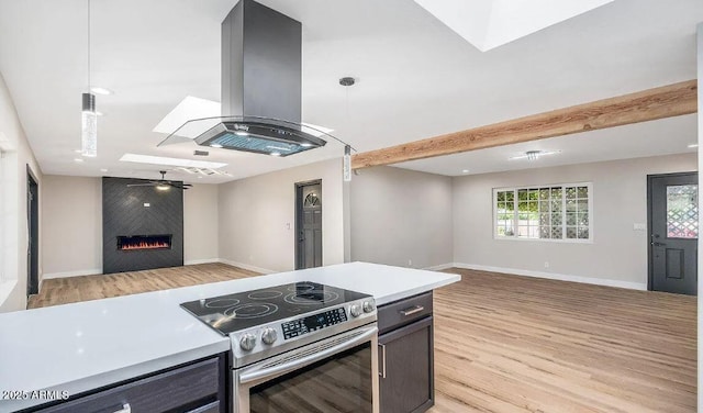 12431 N 30th Ave, Phoenix, AZ 85029 - kitchen featuring stainless steel electric range oven, open floor plan, island range hood, light wood-type flooring, and light countertops