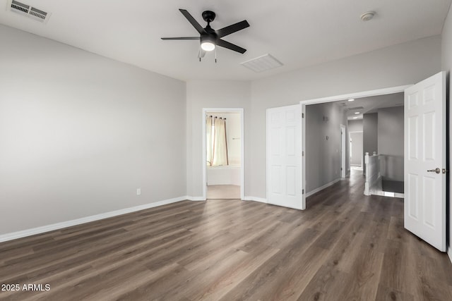 unfurnished bedroom with ceiling fan, dark wood-type flooring, and ensuite bathroom