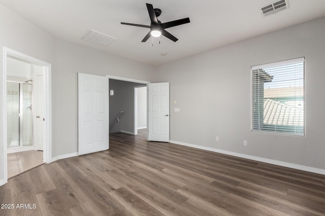 unfurnished bedroom with ceiling fan, ensuite bathroom, and dark hardwood / wood-style floors