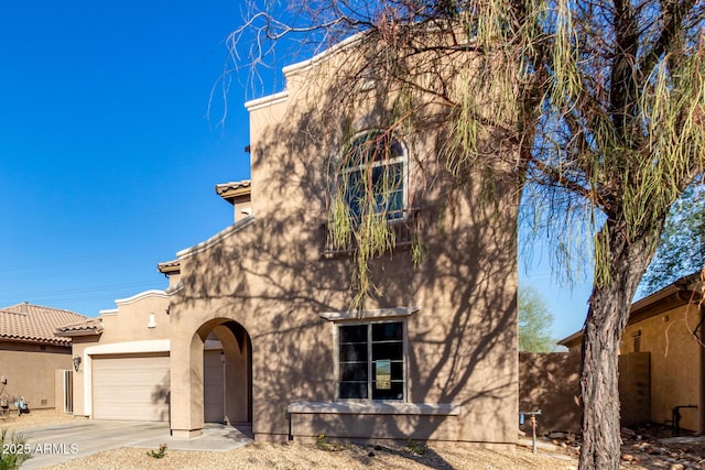 pueblo revival-style home featuring a garage