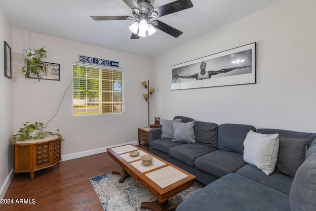 living area with a ceiling fan, baseboards, and wood finished floors