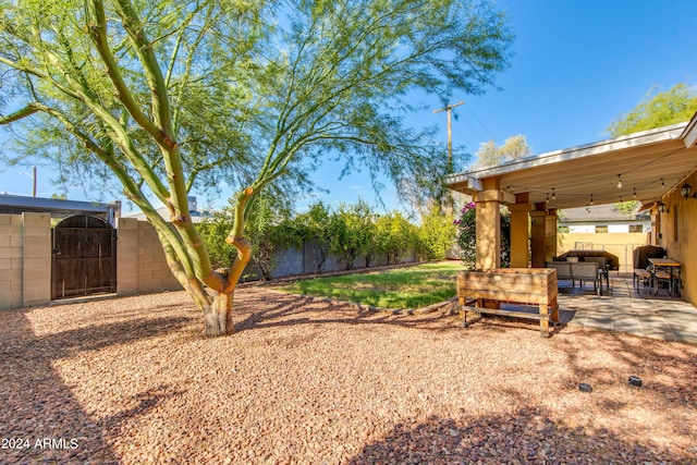 view of yard featuring a gate, fence, and a patio