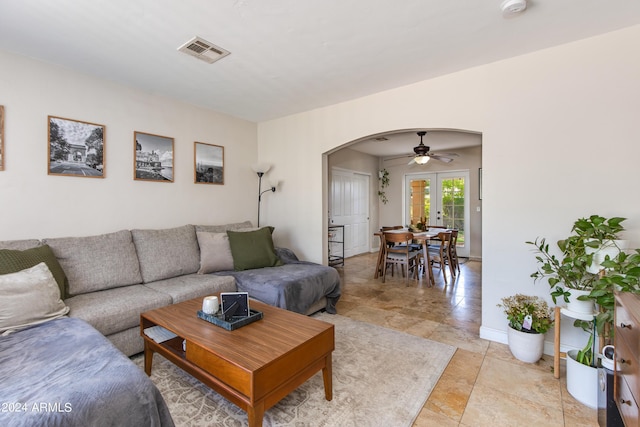 living room featuring arched walkways, french doors, visible vents, and baseboards