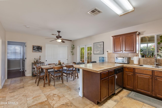 kitchen with visible vents, dishwasher, a peninsula, french doors, and a sink