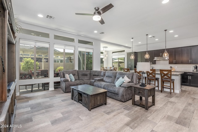 living room with light hardwood / wood-style floors and ceiling fan