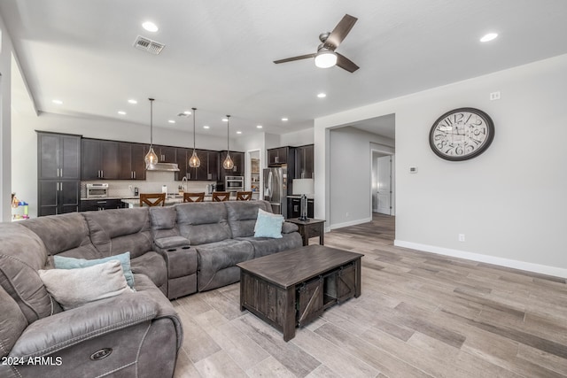 living room featuring ceiling fan and light hardwood / wood-style flooring