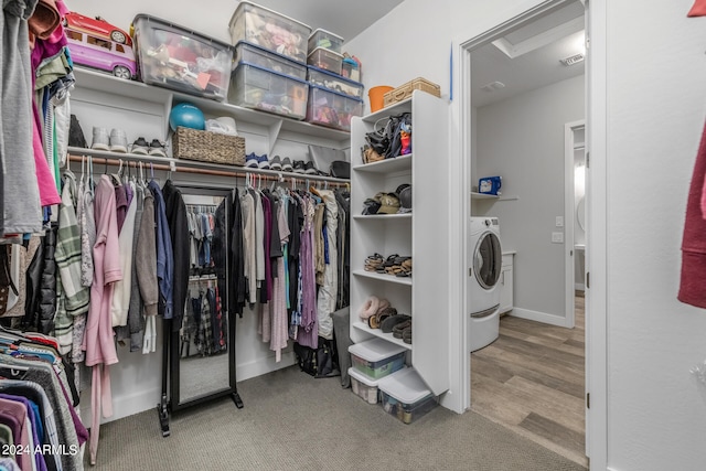 walk in closet with light hardwood / wood-style floors