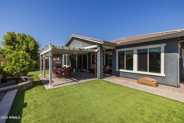 back of house featuring a lawn, a pergola, and a patio