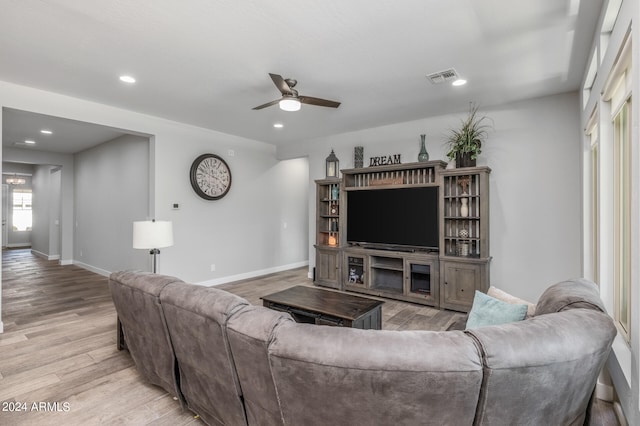 living room with light hardwood / wood-style flooring and ceiling fan