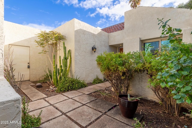 view of property exterior with stucco siding and a tile roof