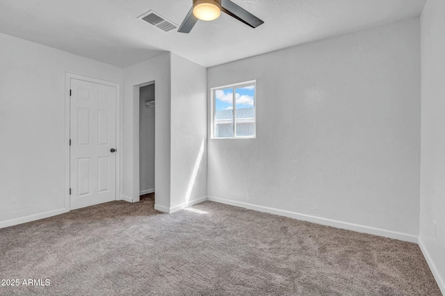 unfurnished bedroom with visible vents, baseboards, a ceiling fan, and carpet floors