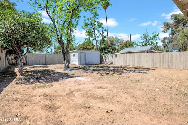 view of yard featuring a fenced backyard, an outbuilding, and a storage shed