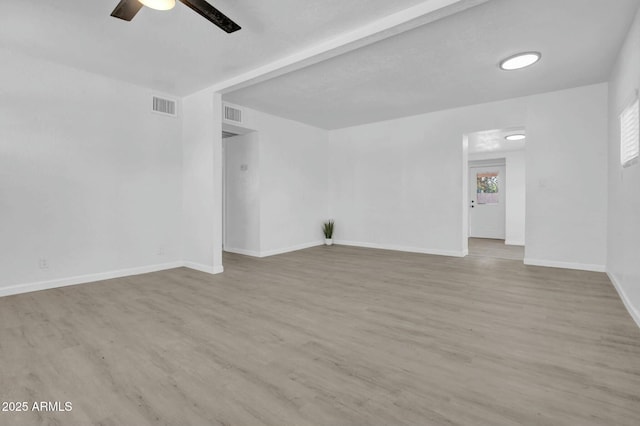unfurnished room featuring baseboards, visible vents, wood finished floors, and ceiling fan